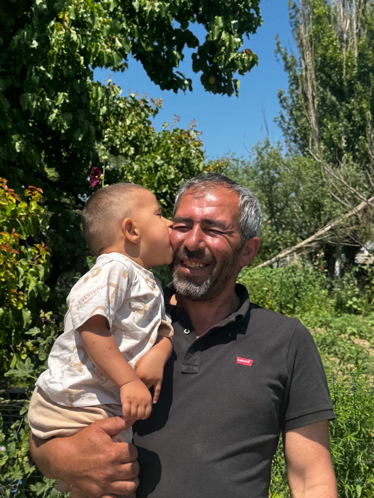 Özbey babasının yanağına öpücük konduruyor