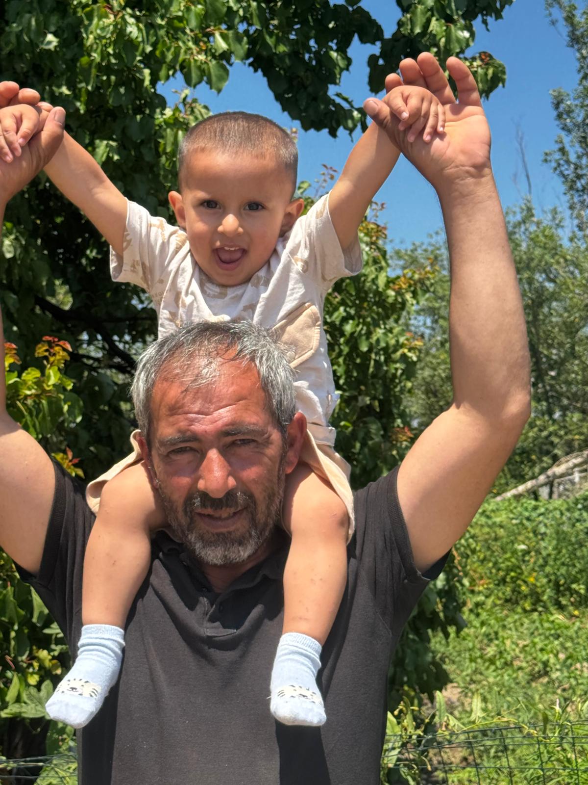 Özbey babasının omuzlarında